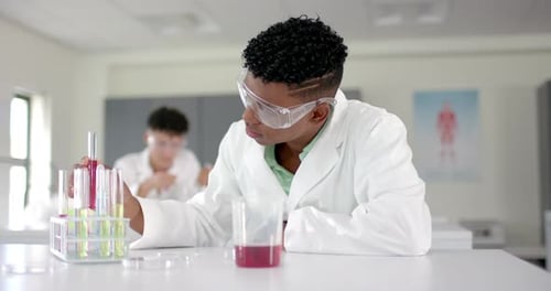 Un adolescente birracial examina un tubo de ensayo en un laboratorio
