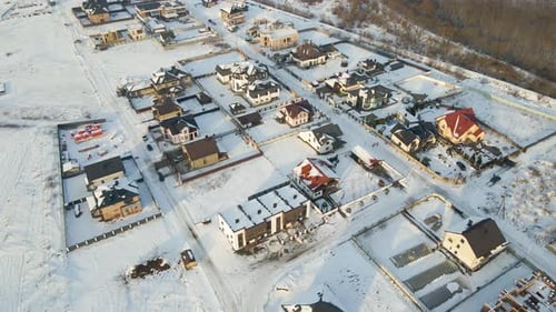 Aerial View of Residential Houses with Snow Covered Roofops in Suburban Rural Town Area in Winter