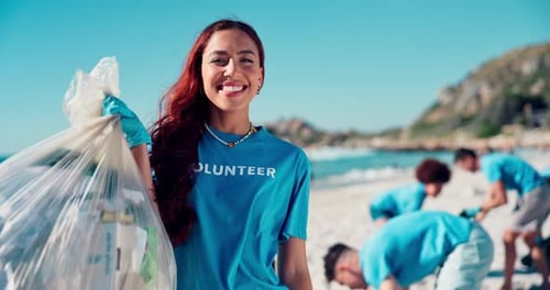 Volunteer, cleaning and face with plastic bag at beach for trash collection