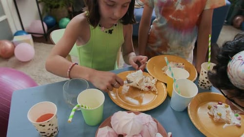 Positive Girl Eating Cake and Looking at Camera while Celebrating Birthday