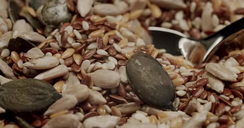 Mezcla de semillas saludables que cae en un tazón de madera