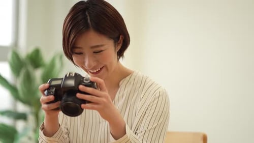 Smiling Woman Looking at Photos on Digital Camera
