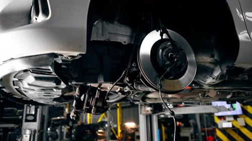 Closeup of a Car Part Raised on a Lift at a Service Station Part of Wheel Without a Tire