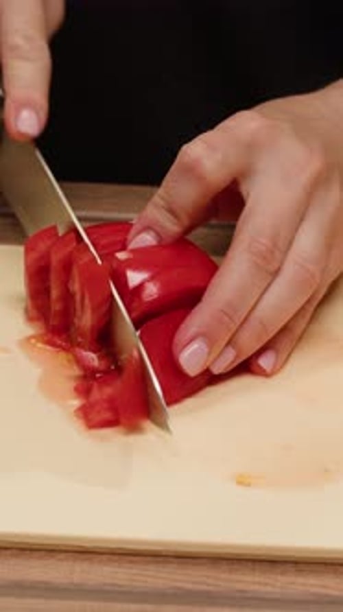 Woman Slices Fresh Red Tomato on Cutting Board