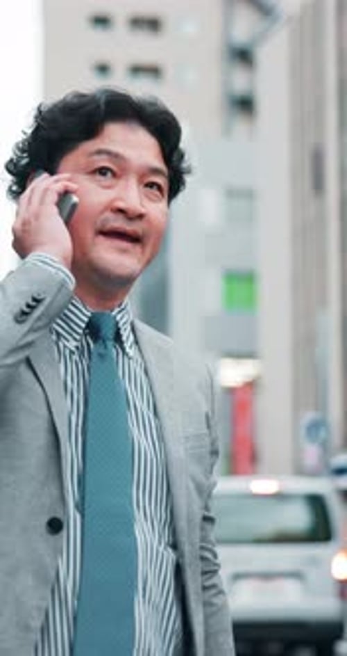 Asian, businessman or hailing with phone call for taxi, lift or ride on sidewalk in Tokyo city