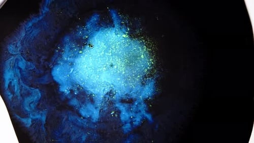 Abstract fluid explosion in vibrant blue, glowing chemical mixing under lens