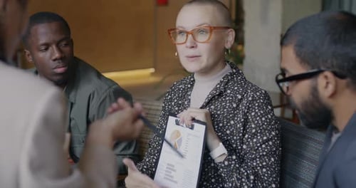 Men and Women Colleagues Discussing Business Document Concentrated on Problem Solving in Office