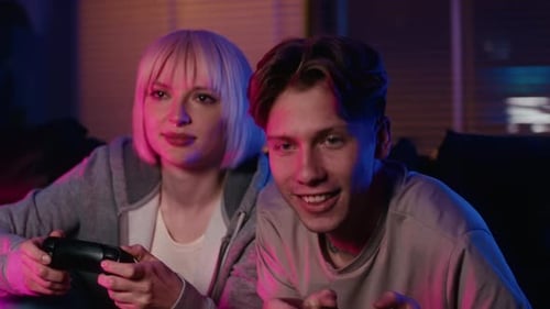 Friends Playing Video Games in Neon Lit Room