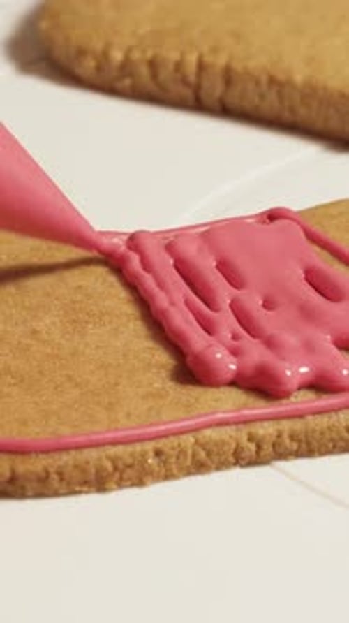pastry chef decorates New Year's gingerbread cookies with colorful glaze Vertical video.