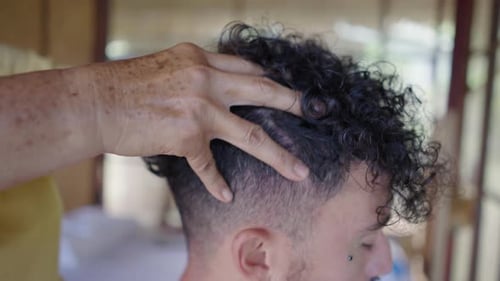 Side View of Mans Head Getting Massaged By Unrecognizable Womans Hands