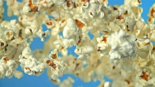 Popcorn Flies Up and Falls Down On a Blue Background Filmed on a Highspeed Camera at 1000 Fps