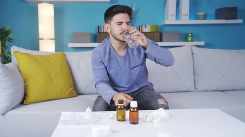 Young man with health problems sneezes and blows his nose.