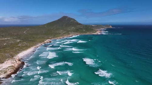 Pointed cape of good hope mountain with azure blue wave swell in foreground