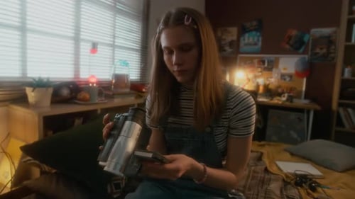 Cheerful Teenage Girl Learning How to Use VHS Camera at Home in 90s