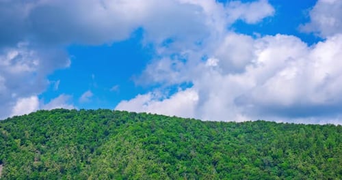 Zeitraffer der Bewegung von Wolken über einem grünen Hügel