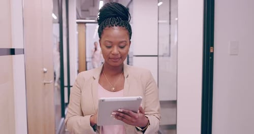 Woman Uses Tablet in Modern Office Hallway