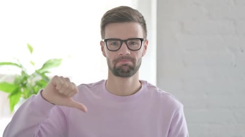 Portrait of Young Man Showing Thumbs Down