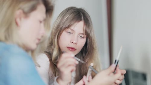 Teenage Girl Learning Makeup Application with Friend