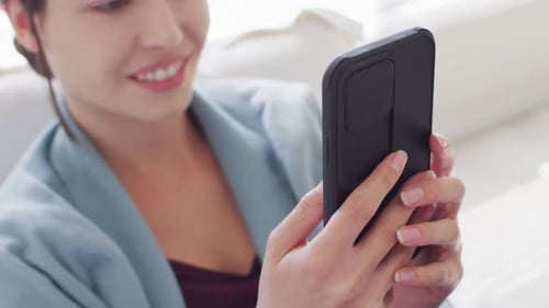 Smiling Woman Using Mobile Phone Indoors