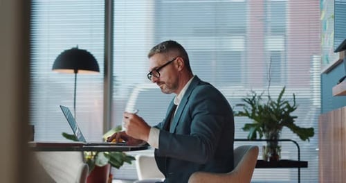 Business, man and writing with laptop in office for research, budget planning and schedule update