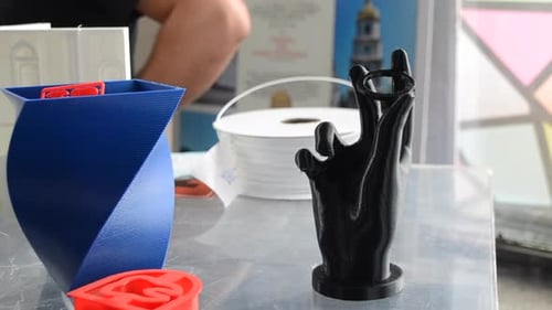 Objetos coloridos brilhantes impressos em uma impressora 3D em uma mesa Closeup
