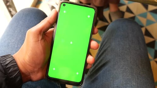 Young Man Hand Using Smart Phone with Green Screen at Cafe