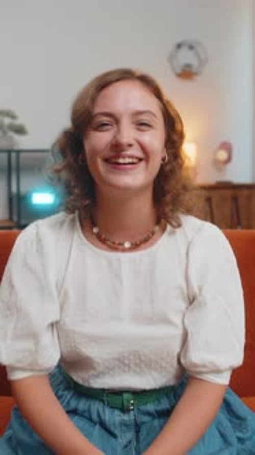 Smiling Woman Sitting on Sofa Indoors