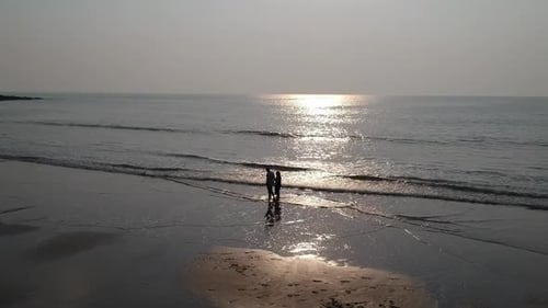 Couple walking at beach - Aerial drone video
