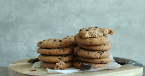 Yummy chocolate chip cookies on wooden table, rotating