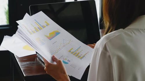 Woman Reviewing Sales Reports at Work
