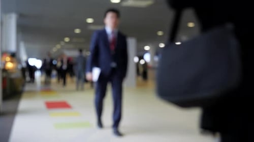 Blurry View of Businessmen Walking in Lobby Media A Lot of Businessmen are Walking Through Lobby of