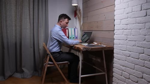 Man Working At Home Using Laptop and Tablet