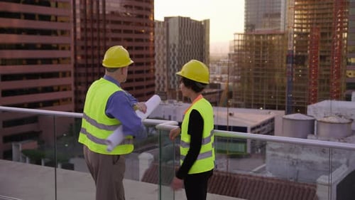Two Construction Supervisors Look at Plans on Rooftop Architect