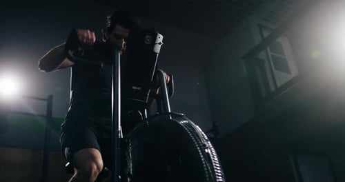 Extreme Atheltics - Male athlete riding exercise bike