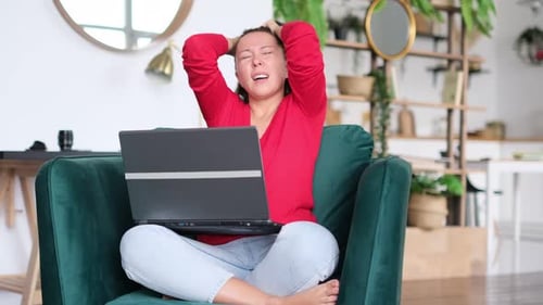 Woman Celebrating Good News on Laptop at Home