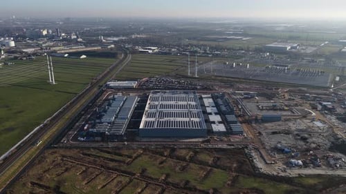 Wide aerial view of newly built data center complex with multiple modern buildings blending