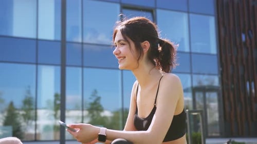 Young Woman Talking and Holding Phone Outside