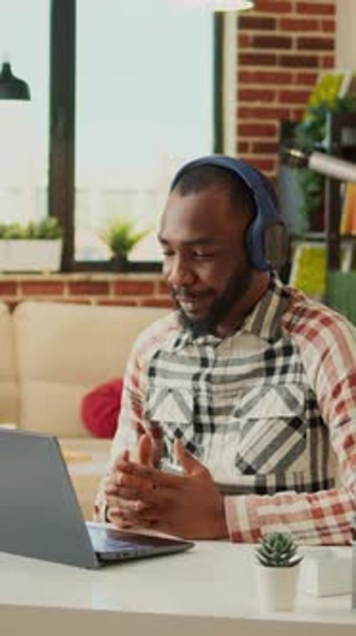 Adult Using Laptop with Headphones at Home