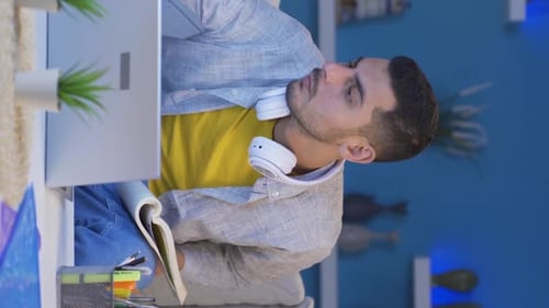 Man Studying With Laptop and Notebook at Home