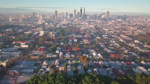 Forward aerial view of Perth city from Northern suburbs in early morning as the sun rises with soft