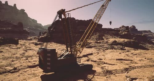Heavy Machinery Operates in Rocky Terrain Under Clear Skies at Sunrise