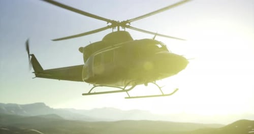 Helicóptero sobrevolando las montañas al atardecer durante un vuelo aventurero