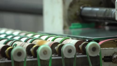 Quadratische Glasscheibe auf der werksseitigen Förderrolle. Transport von Glaselementen mit mehrfachem Spinnin