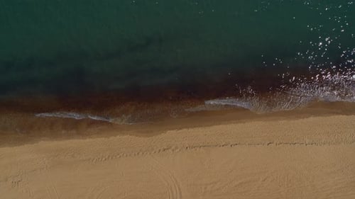 Aerial Top View Sand Beach Calm Sea Waves Splashing Seashore. Drone