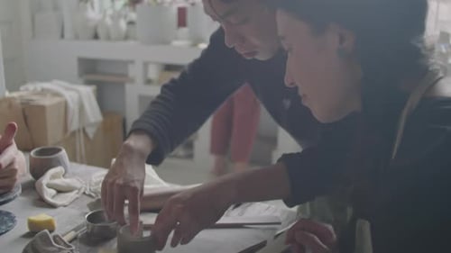 Adults Shaping Clay Pottery in Bright Art Studio