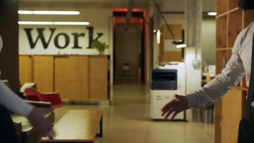 Successful businessman shaking hands with woman colleague in busy italian office