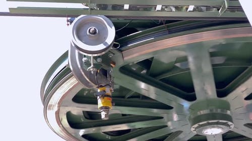 Close up on cable car driving mechanism. Rotating metal wheel powering gondola