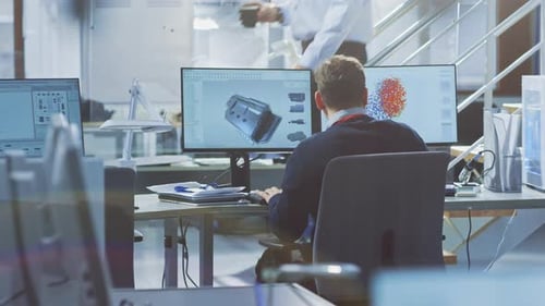 Rückansicht eines Wirtschaftsingenieurs, der in Bright Office am Desktop-Computer arbeitet. Bildschirme zeigen IDE/C