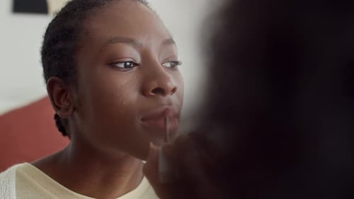 Mädchen trägt Lippenstift auf, wenn sie ihren Freund schminkt