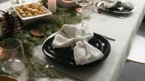 Glossy Black Plates with White Napkin on Elegantly Arranged Christmas Table